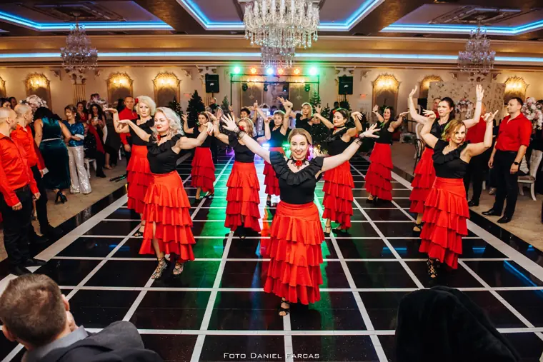 Formație în fuste roșii de flamenco, pe podeaua cu grilă luminoasă